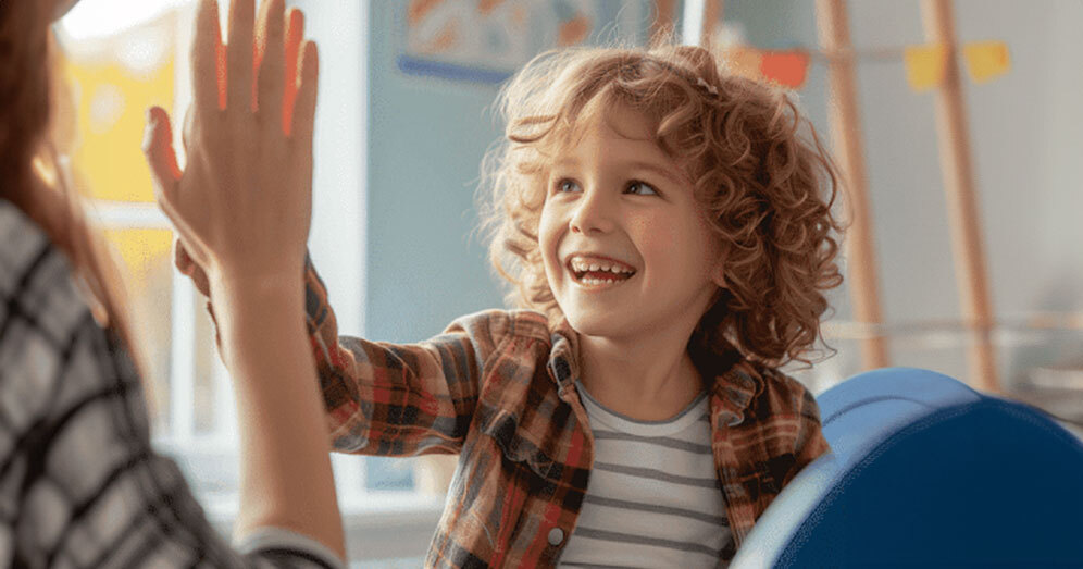 Child celebrating progress with therapist in ABA therapy