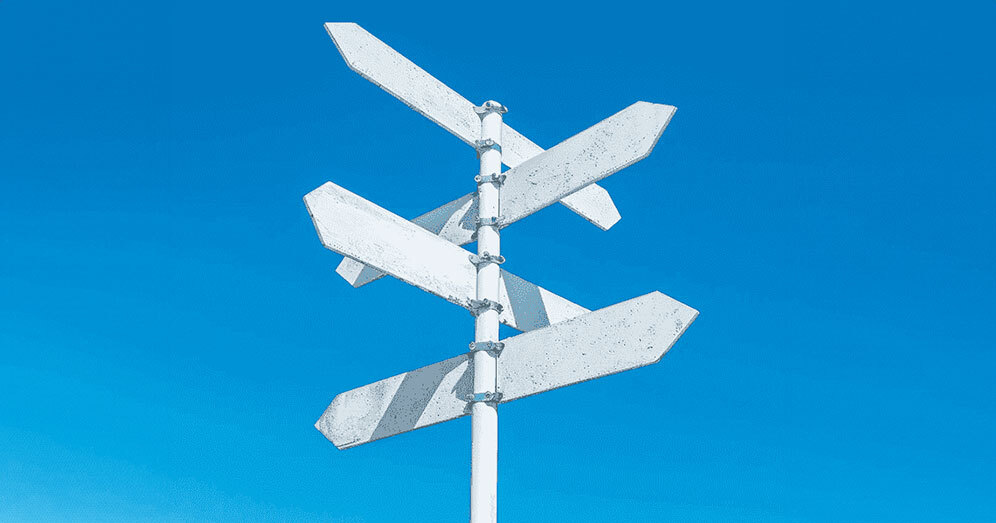 Crossroads signpost under a clear blue sky indicating future paths