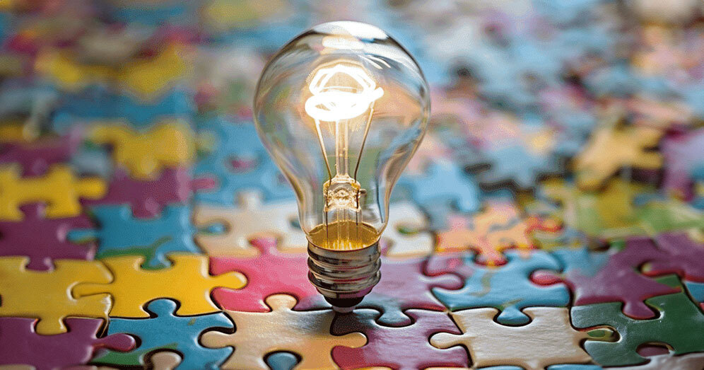 lluminated light bulb over a colorful puzzle representing enlightenment on ABA therapy myths