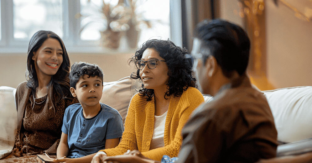 Therapist and family engaging in a collaborative discussion in a comfortable setting
