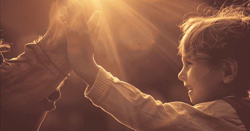 Child and therapist celebrating progress with a high-five in a bright, positive setting.